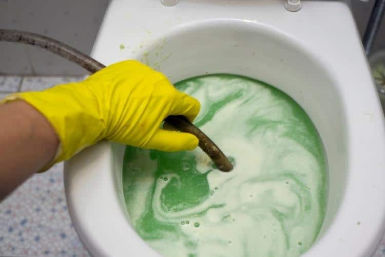 desentupir com diabo verde: homem desentupindo vaso sanitário